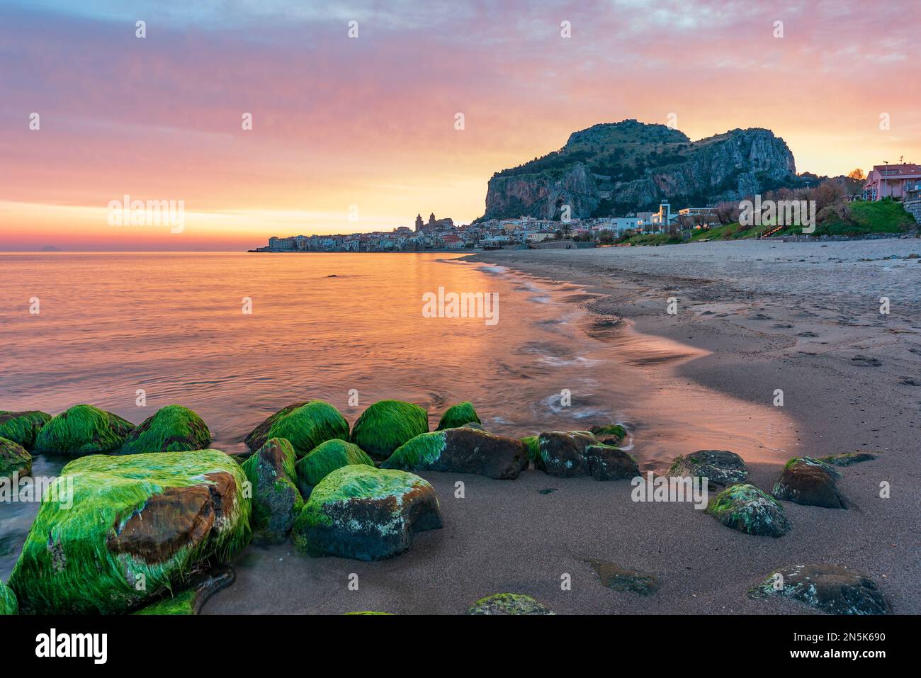 La plage de Cefalù avec la ville en arrière-plan aux premières lumières du matin, Sicile Banque D'Images