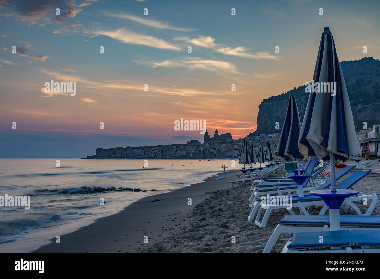 La plage de Cefalù avec la ville en arrière-plan aux premières lumières du matin, Sicile Banque D'Images