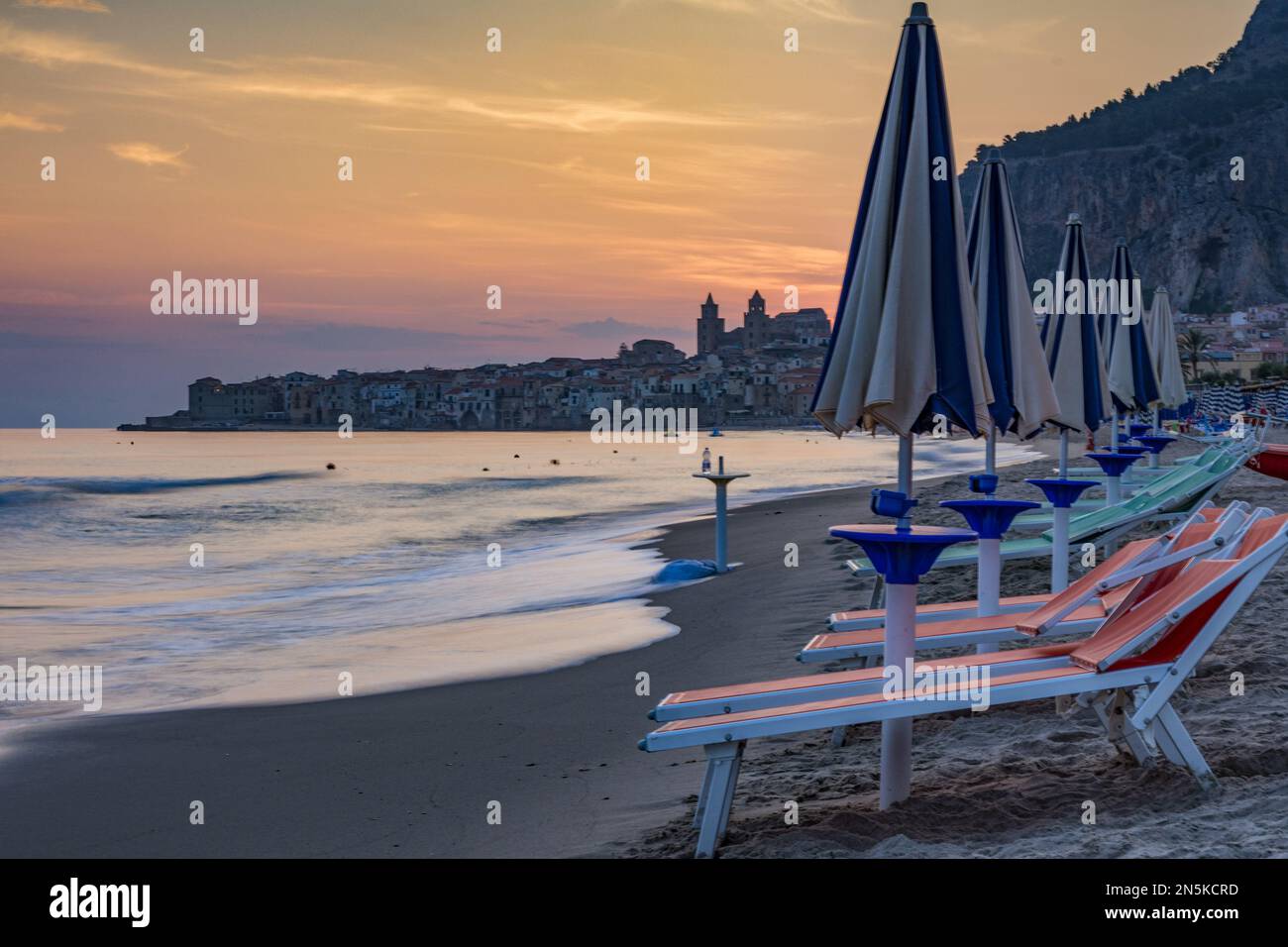La plage de Cefalù avec la ville en arrière-plan aux premières lumières du matin, Sicile Banque D'Images