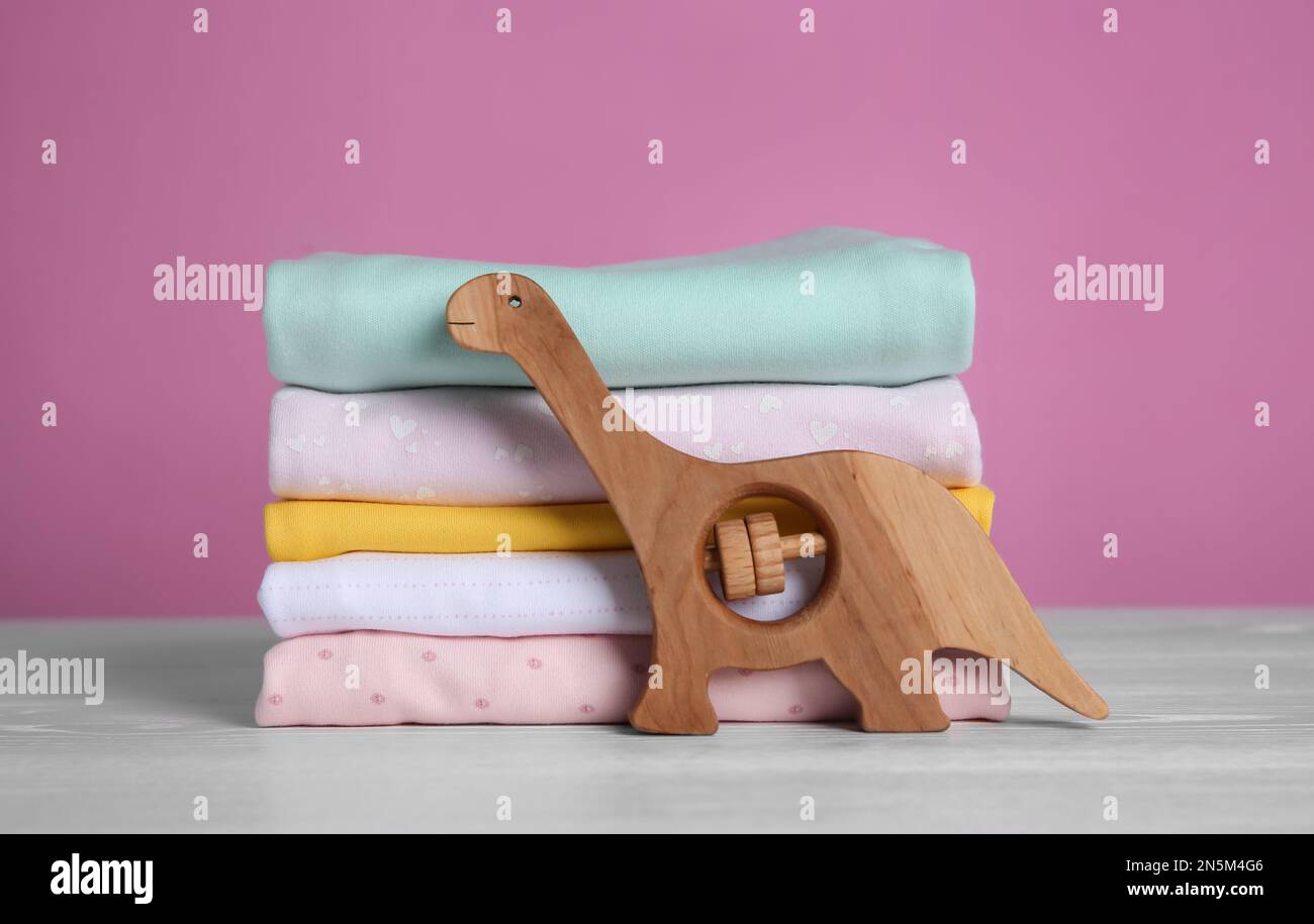 Pile de vêtements et de jouets pour enfants sur une table en bois blanc Banque D'Images