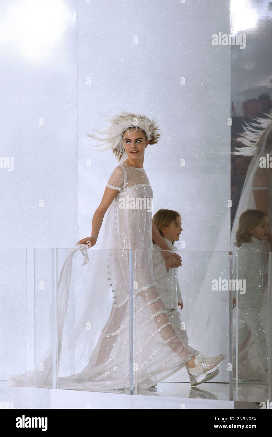 Model Cara Delevingne, left, holding the hand of Hudson Kroenig, 5, son of U.S. model Brad Kroening, wears the wedding gown during Chanel's Spring-Summer 2014 Haute Couture fashion collection presented in Paris, Tuesday, Jan.21, 2014. (AP Photo/Thibault Camus) Banque D'Images