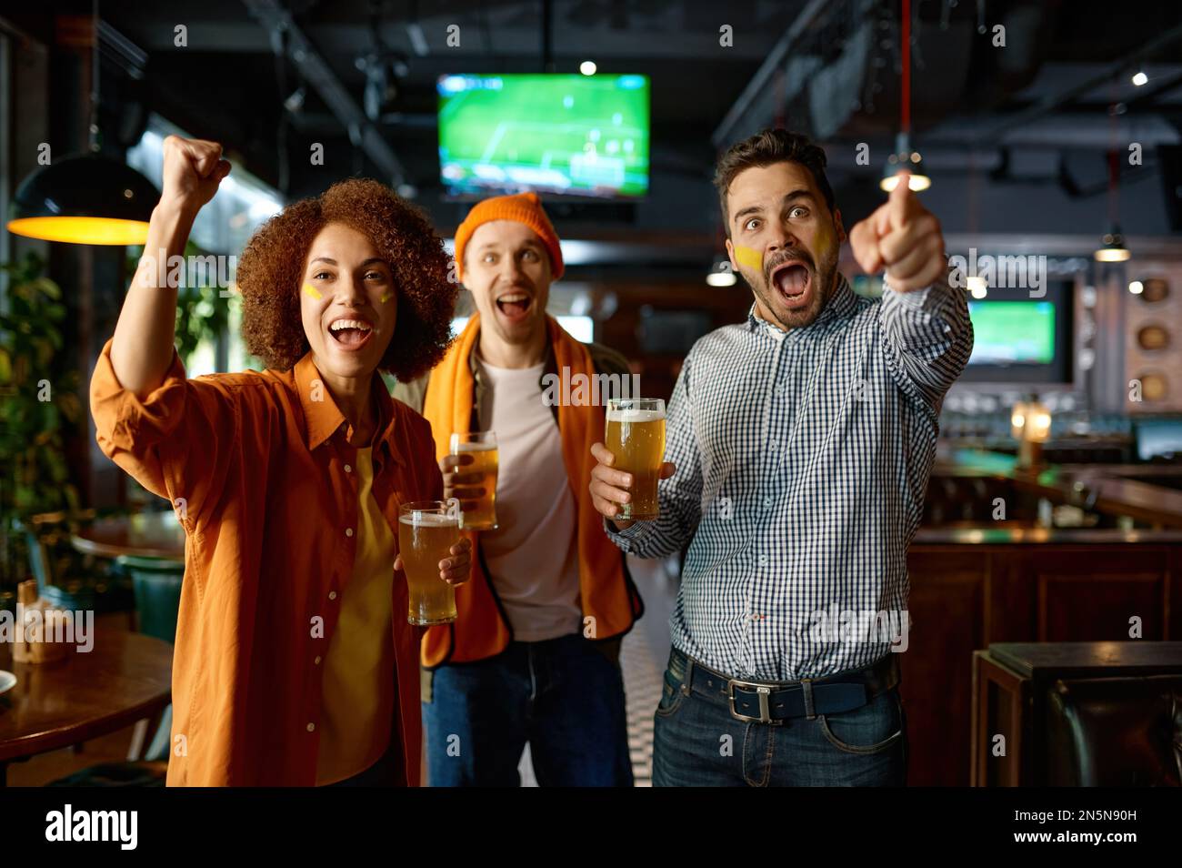 Groupe d'amis émotifs regardant le football au pub Banque D'Images
