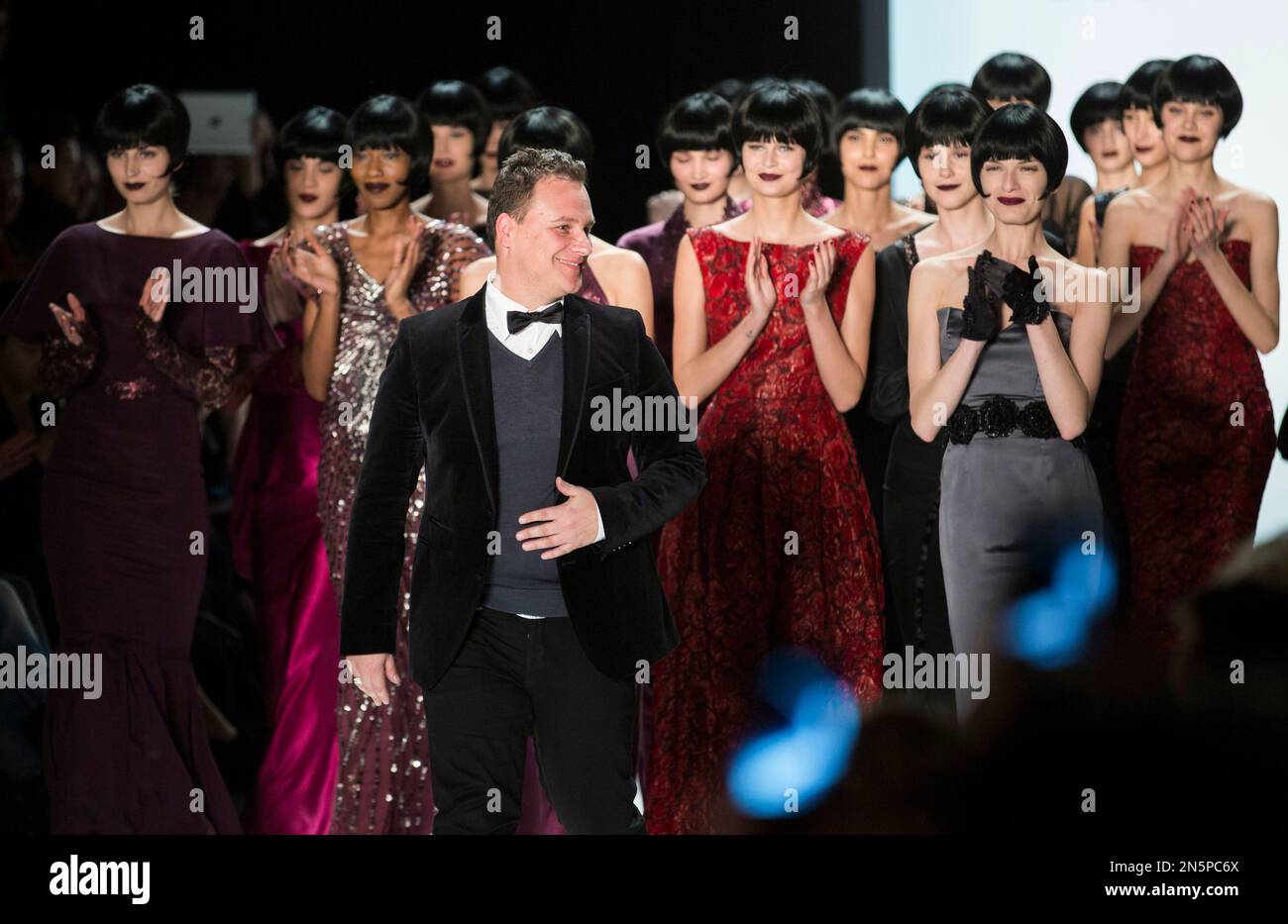 Fashion designer Guido Maria Kretschmer and his models walk on the catwalk after his Autumn Winter 2014 collection show during Fashion Week in Berlin, Germany, Thursday, Jan. 16, 2014. (AP Photo/Gero Breloer) Banque D'Images