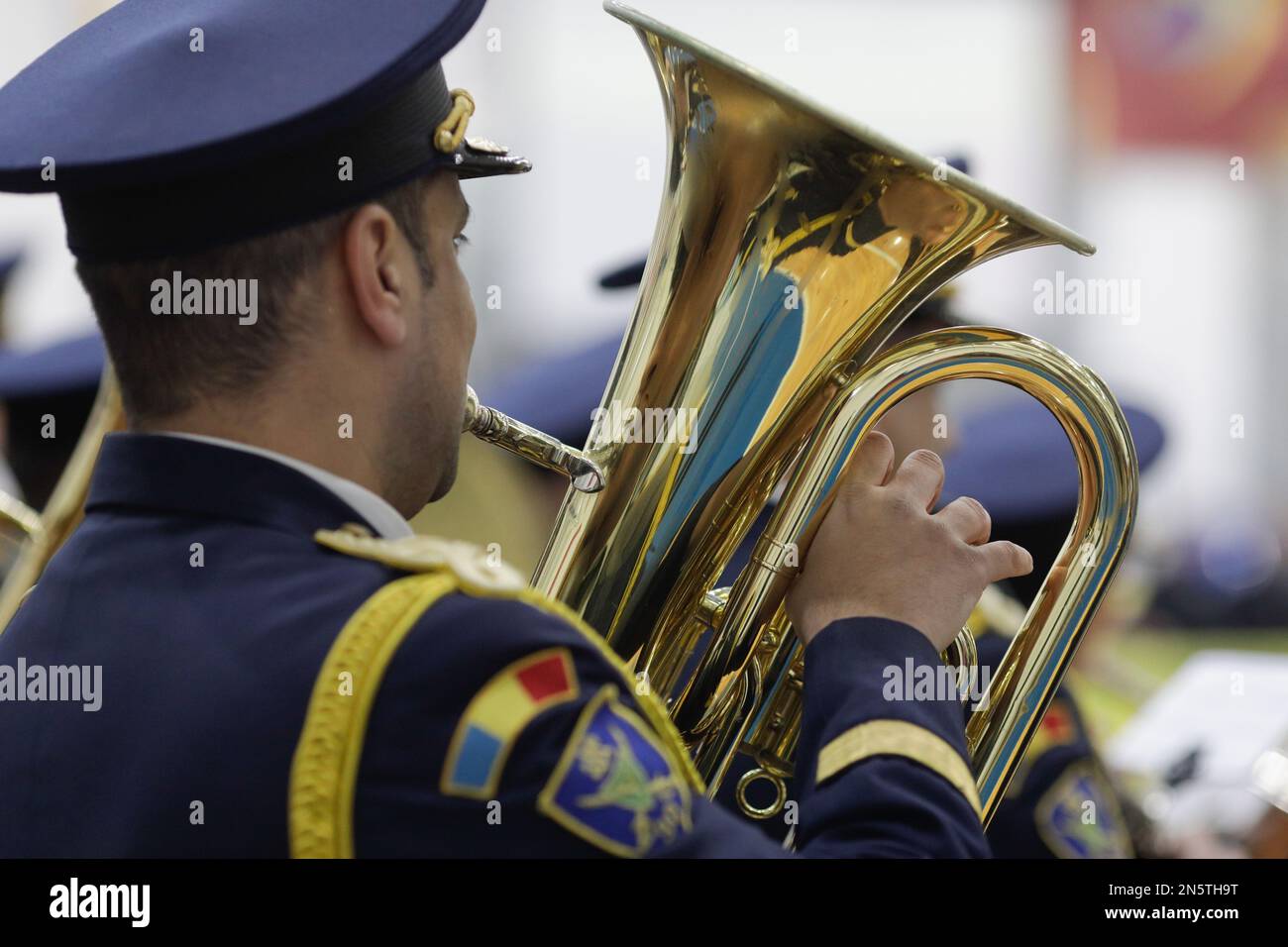 Bucarest, Roumanie -9 février 2023: Détails avec les mains d'un membre de fanfare militaire tenant un instrument de musique à vent en laiton. Banque D'Images