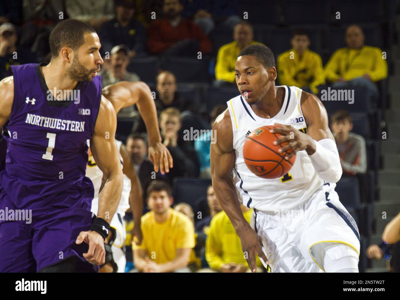 Northwestern guard Drew Crawford, left, defends against Michigan forward Glenn Robinson III (1) in the first half of an NCAA college basketball game in Ann Arbor, Mich., Sunday, Jan. 5, 2014. (AP Photo/Tony Ding) Banque D'Images