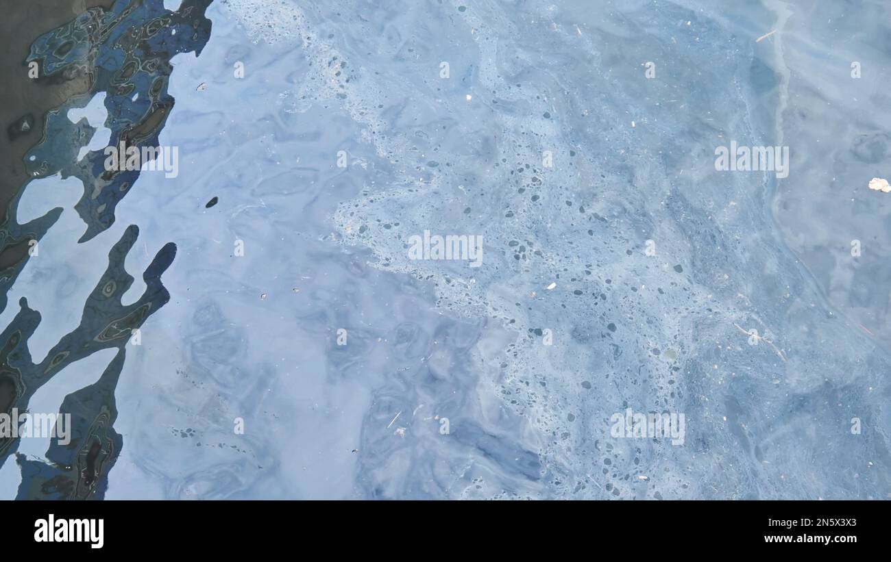 Une tache d'essence sur la mer au large de la côte de la ville. Banque D'Images