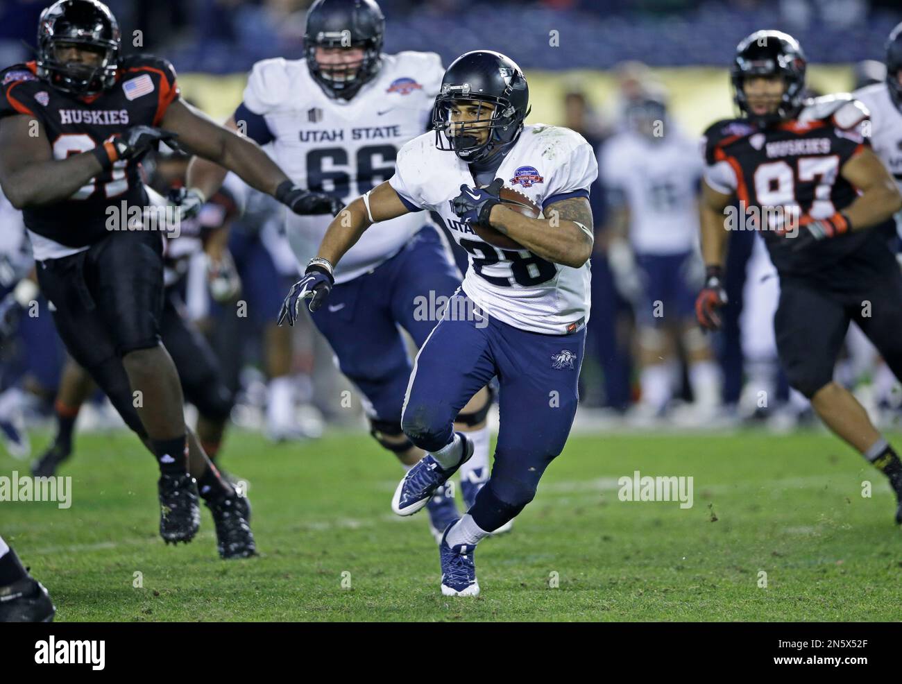 Utah State running back Joey DeMartino breaks through the Northern Illinois defense while gaining part of his 143 yards rushing during Utah State's 21-14 victory in the Poinsettia Bowl NCAA college football game, Thursday, Dec. 26, 2013, in San Diego. DeMartino was named the offensive player of the game. (AP Photo/Lenny Ignelzi) Banque D'Images