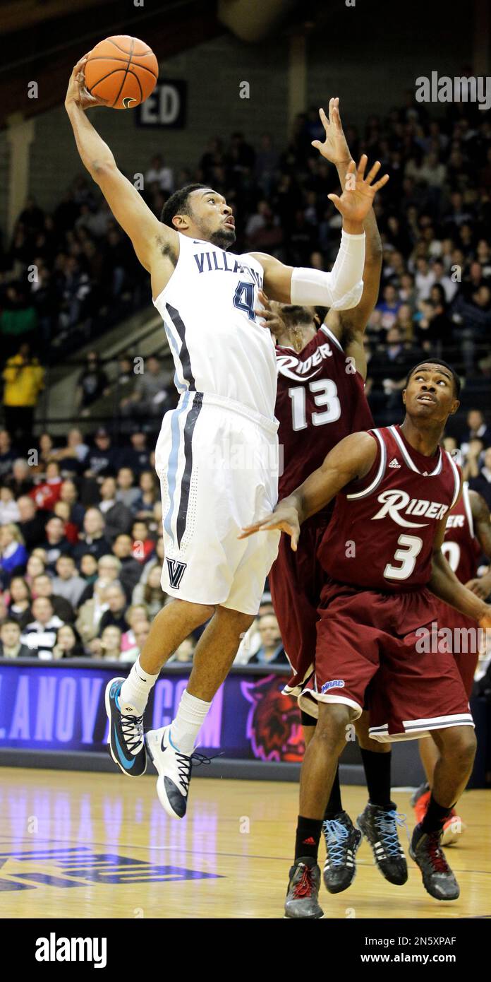 Villanova's Darrun Hilliard (4) drives to the basket past Rider's Daniel Stewart (13) and Jimmie Taylor (3) in the first half of an NCAA college basketball game, Saturday, Dec. 21, 2013, in Villanova, Pa. (AP Photo/Laurence Kesterson) Banque D'Images
