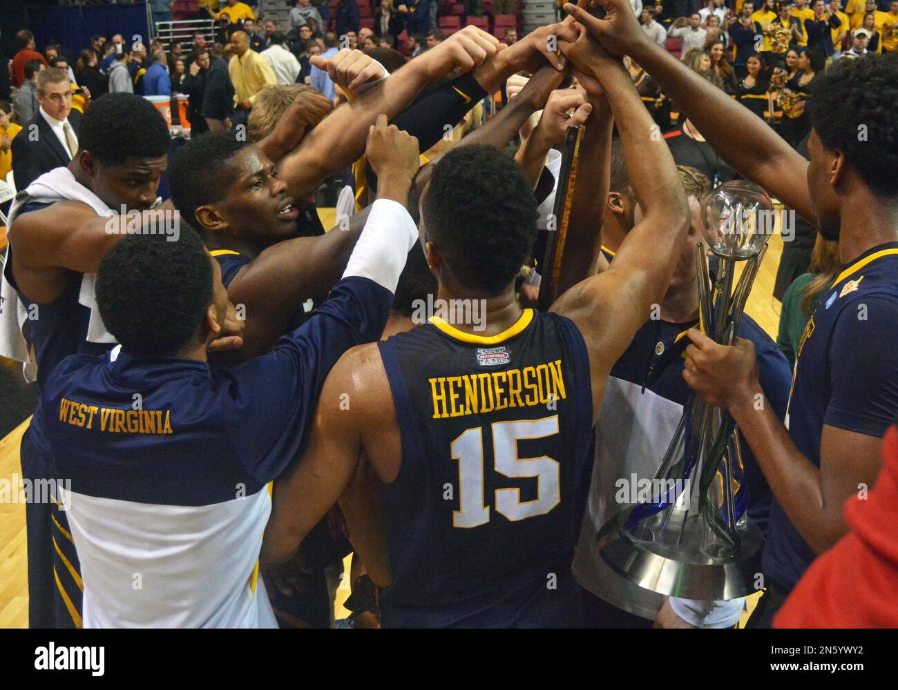 West Virginia's Terry Henderson (15) and game MVP Brandon Watkins celebrate with the team after an NCAA college basketball game against Marshall, Saturday, Dec. 14, 2013, in Charleston, W.Va. West Virginia won 74-64. (AP Photo/Tyler Evert) Banque D'Images