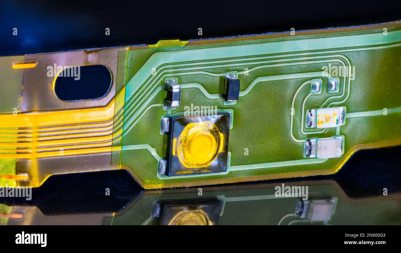 Gros plan de la carte électronique à circuit imprimé flexible avec réflexion sur fond noir brillant. Bande plastique plate avec petits composants montés en surface. Banque D'Images
