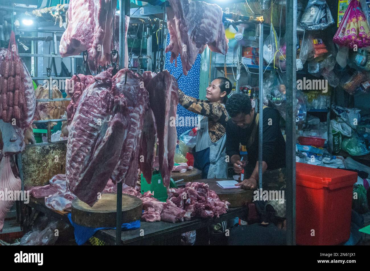 Un couple cambodgien heureux vend de la viande crue au marché principal des légumes et de la viande de gros la nuit. Phsar Dumkor, Phnom Penh, Cambodge. © Kraig Lieb Banque D'Images