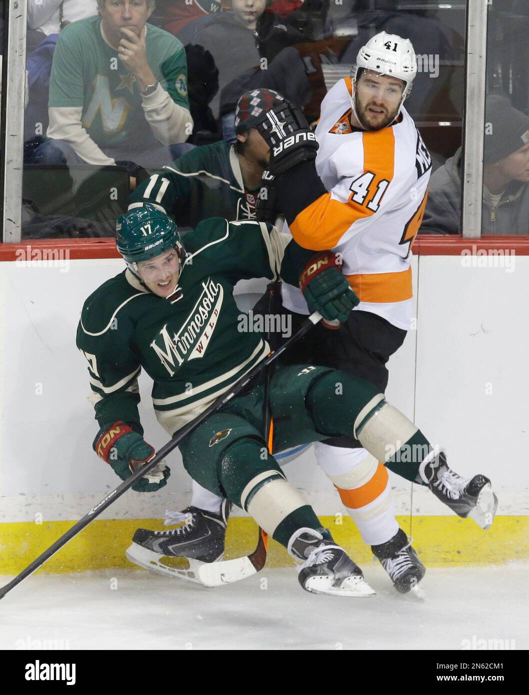 Minnesota Wild's Torrey Mitchell, left, slips and falls as he checks Philadelphia Flyers defenseman Andrej Meszaros of Slovakia in the first period of an NHL hockey game, Monday, Dec. 2, 2013, in St. Paul, Minn. (AP Photo/Jim Mone) Banque D'Images