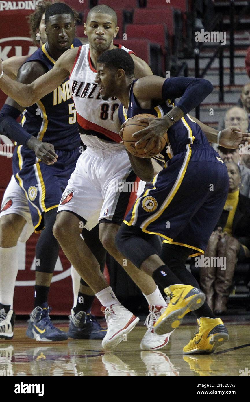 Indiana Pacers forward Paul George, right drives on Portland Trail Blazers forward Nicolas Batum, from France, during the first half of an NBA basketball game in Portland, Ore., Monday, Dec. 2, 2013. (AP Photo/Don Ryan) Banque D'Images