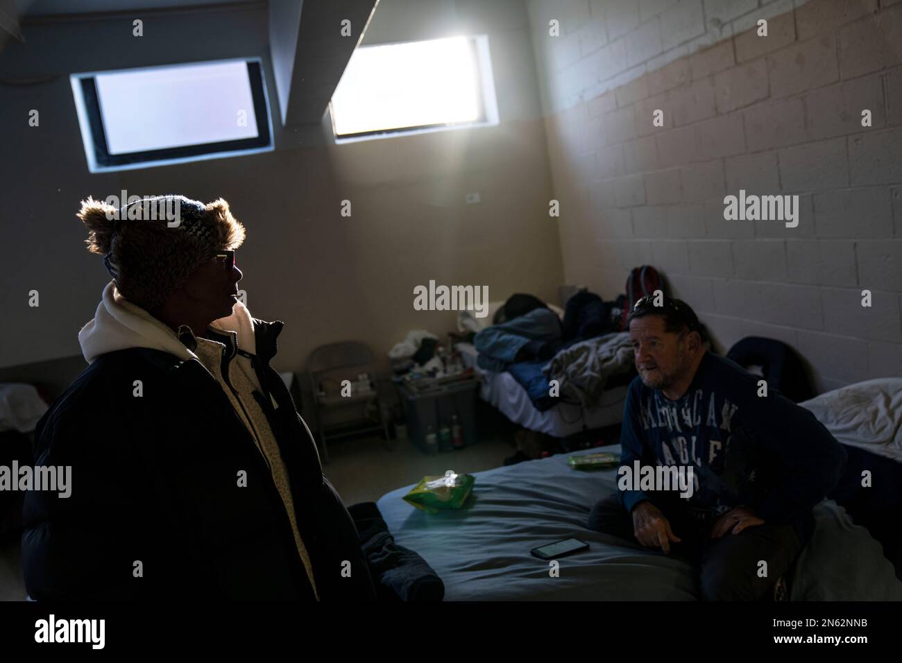 Shelter advocate Ron Moore, left, talks with Donald Cabral who rests on
