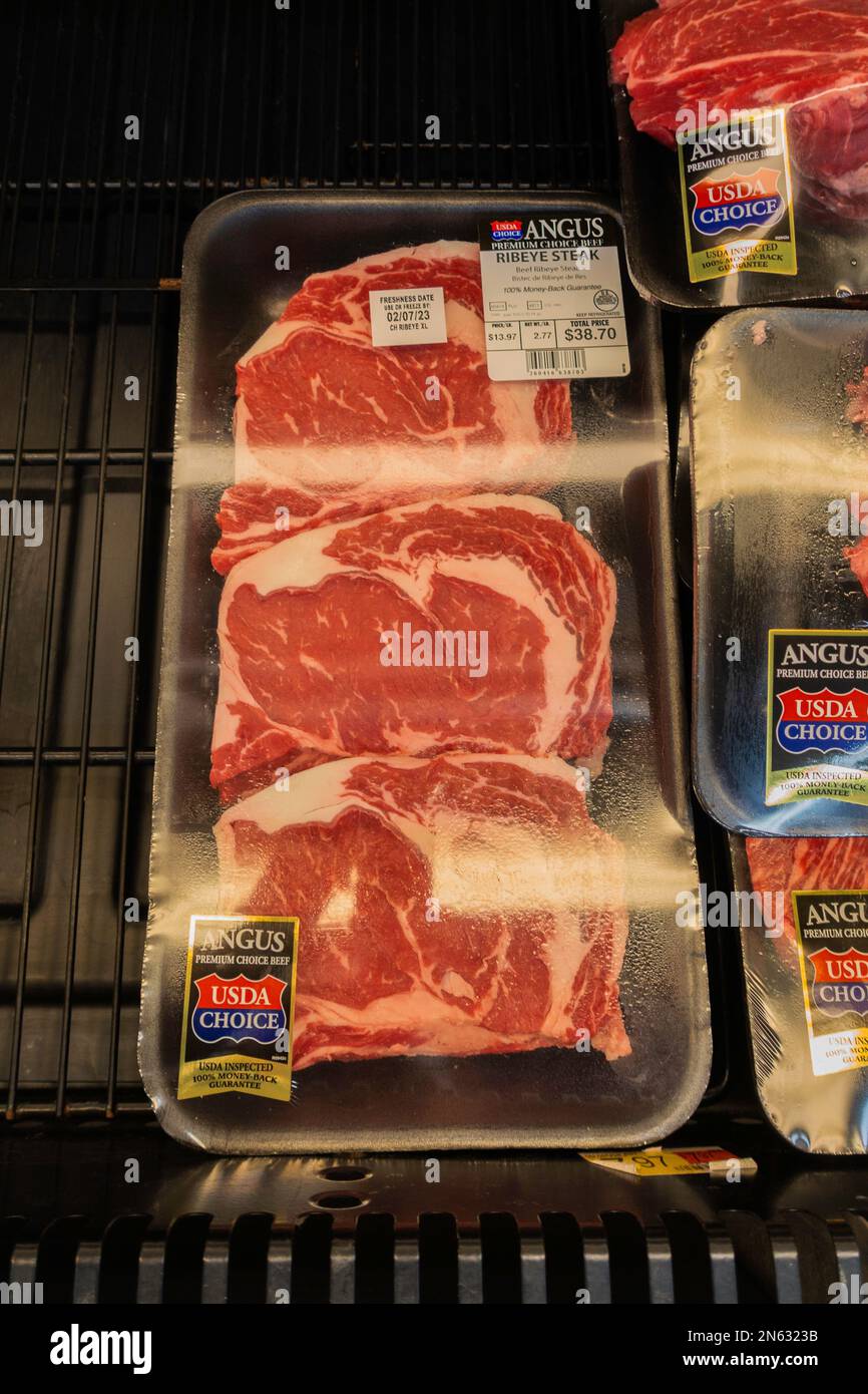 Emballage de biftecks de ribeye crus dans un bac de refroidissement du magasin. Wichita, Kansas, États-Unis. Banque D'Images