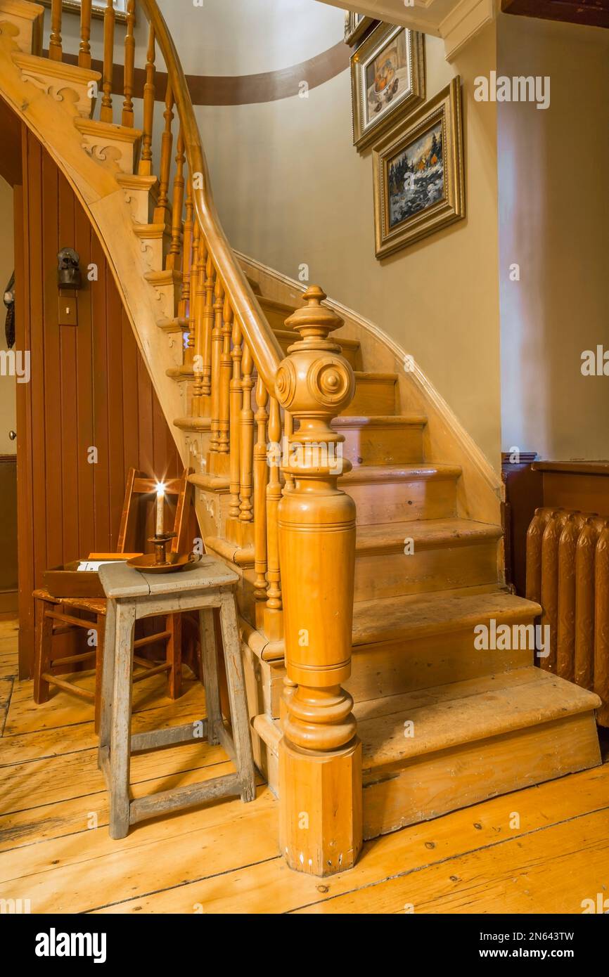 Escalier en bois incurvé avec poteau de fantaisie et balusters au rez-de-chaussée à l'intérieur de la vieille maison de style cottage de 1805. Banque D'Images