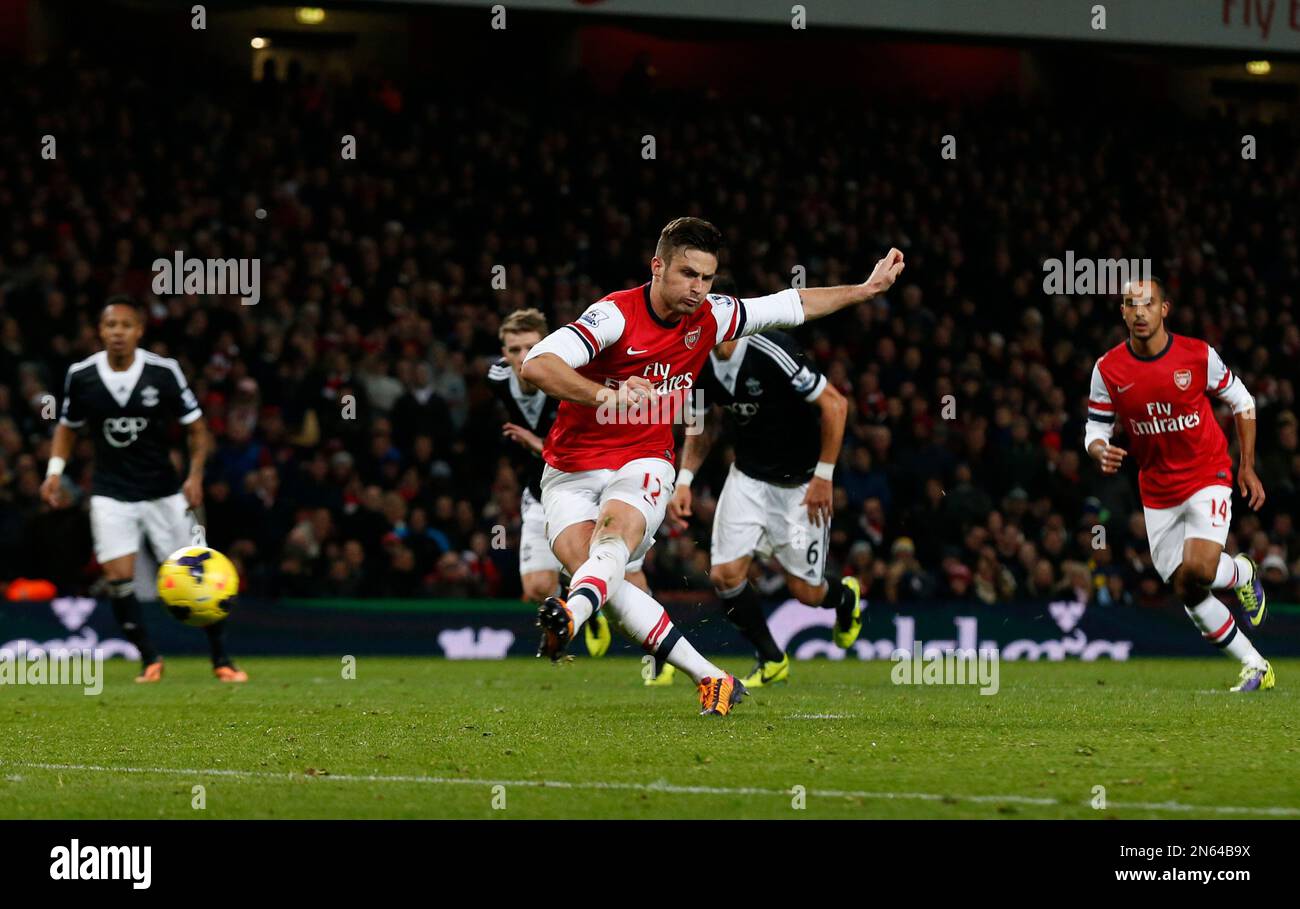 Arsenal's Olivier Giroud, center, scores a penalty during the English Premier League soccer match between Arsenal and Southampton at the Emirates Stadium in London, Saturday, Nov. 23, 2013. (AP Photo/Matt Dunham) Banque D'Images