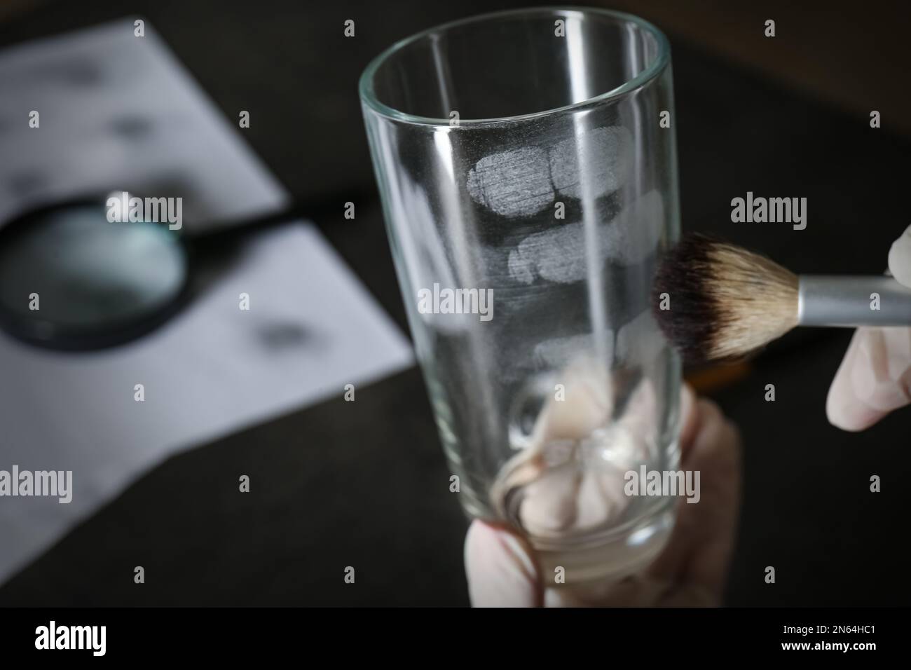 Détective prenant des empreintes digitales avec la brosse du verre, gros plan Banque D'Images