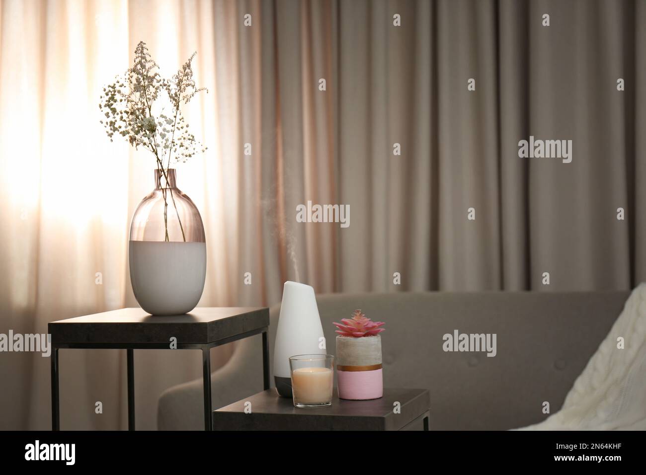 Diffuseur d'huile aromatique et bougie sur table dans la chambre Banque D'Images