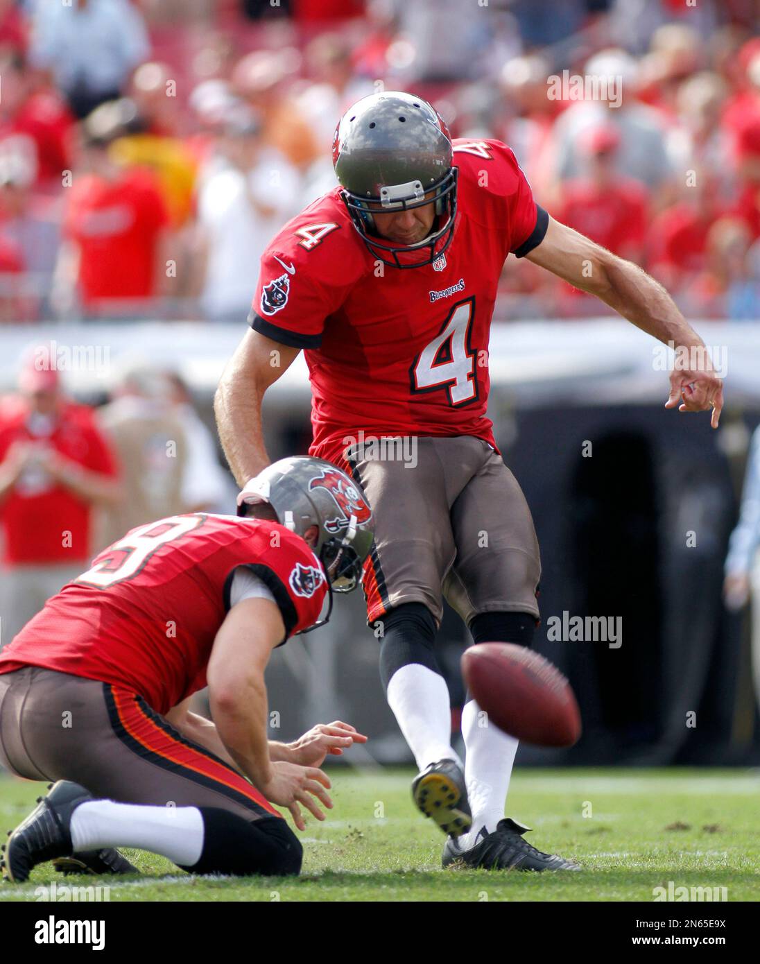 Tampa Bay Buccaneers kicker Rian Lindell (4) kicks a field goal from the hold of Tampa Bay Buccaneers punter Michael Koenen (9) during the first half of an NFL football game on Sunday, Nov. 17, 2013 in Tampa, Fla.. The Buccaneers beat the Falcons 41-28. (AP Photo/Reinhold Matay) Banque D'Images