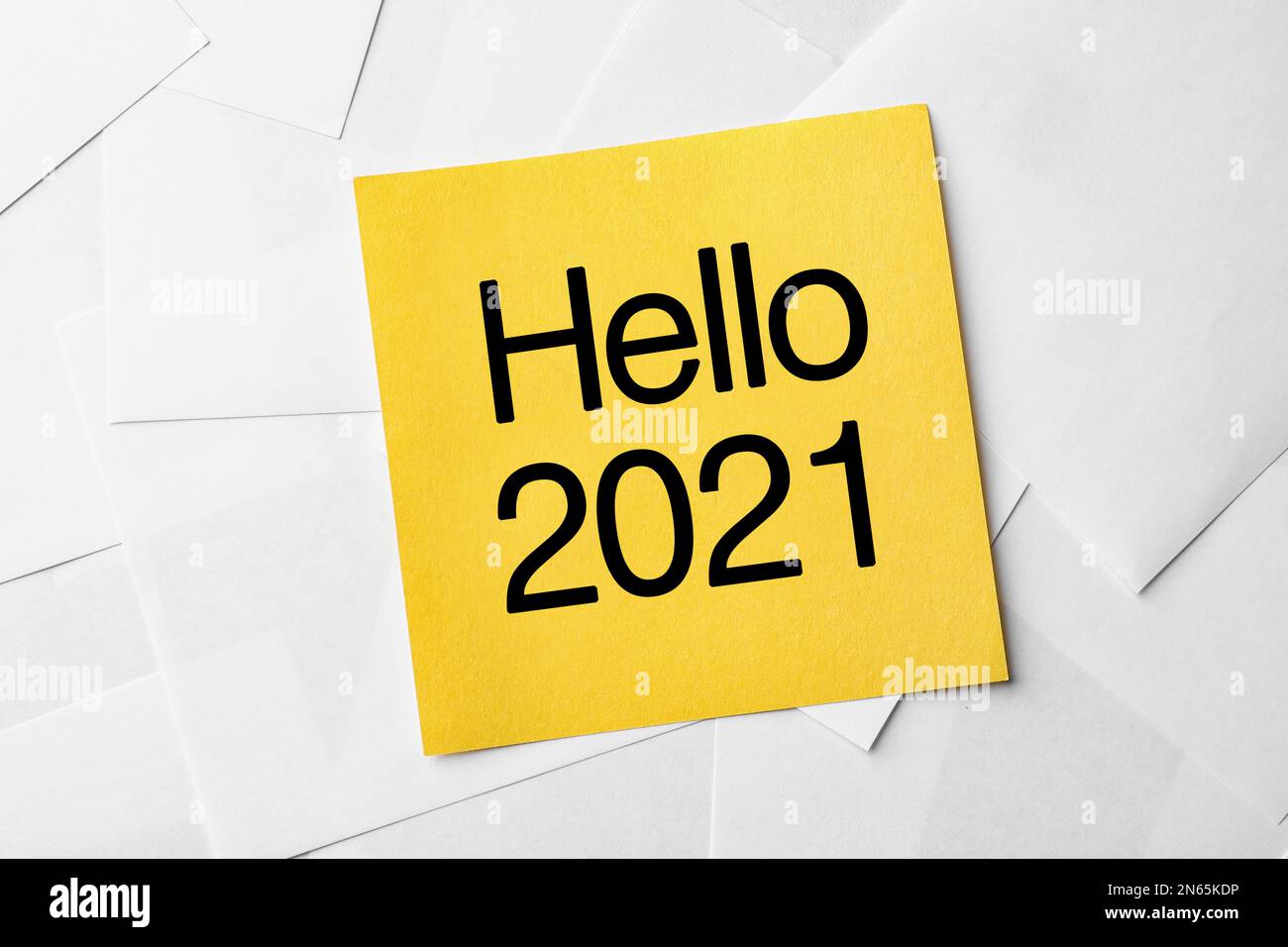 Note avec texte Hello 2021 sur feuilles de papier, vue de dessus Banque D'Images