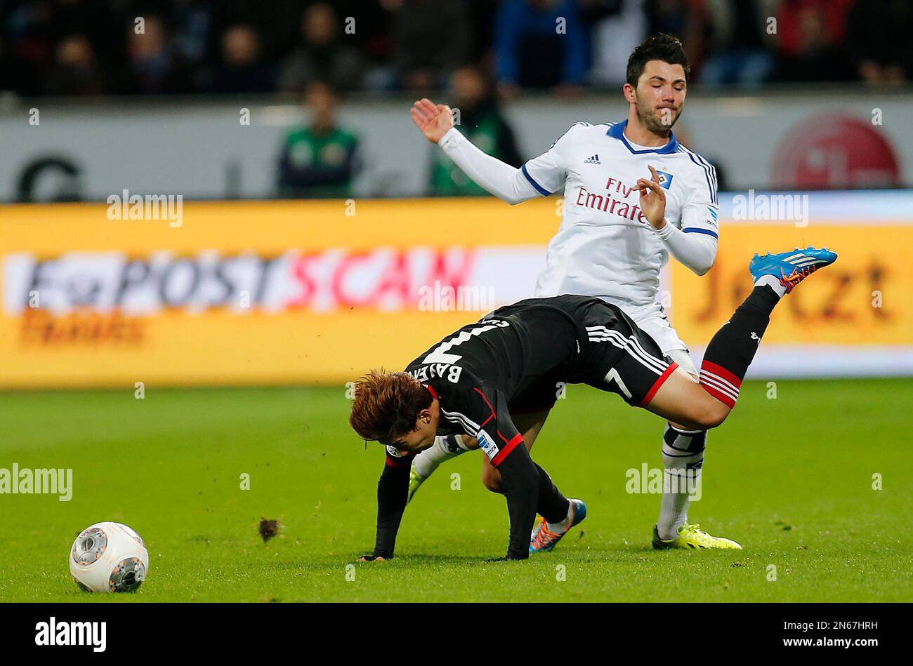 Leverkusen's Son Heung-min of South Korea, front, is fouled by Hamburg's Tolgay Arslan during the German first division Bundesliga soccer match between Bayer Leverkusen and Hamburg SV in Leverkusen, Germany, Saturday, Nov. 9, 2013. (AP Photo/Frank Augstein) Banque D'Images