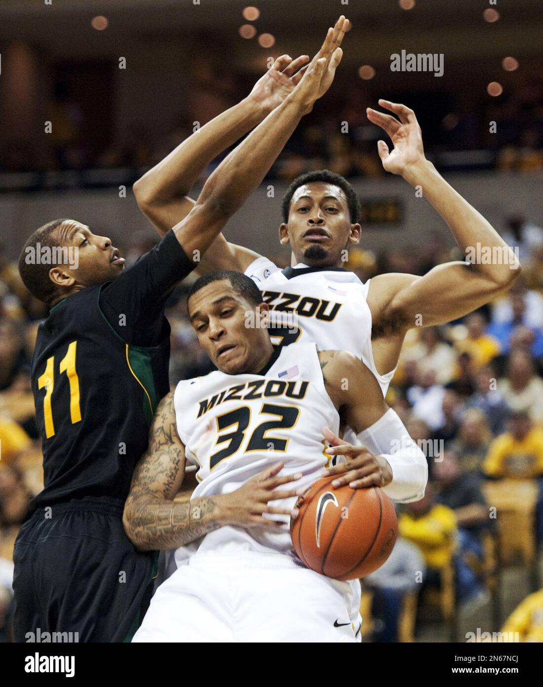 Missouri's Jabari Brown, center, pulls down a rebound past teammate Johnathan Williams III, back, and Southeastern Louisiana's Antonnio Benton, left, during the second half of an NCAA college basketball game Friday, Nov. 8, 2013, in Columbia, Mo. Missouri won 89-53. (AP Photo/L.G. Patterson) Banque D'Images