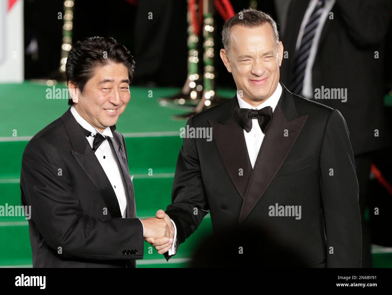 Tom Hanks, right, and Japanese Prime Minister Shinzo Abe smile as they greet each other upon arriving on the green carpet for the opening ceremony of the 26th Tokyo International Film Festival in Tokyo Thursday, Oct. 17, 2013. Hanks' film "Captain Phillips" will be shown as the opening film in the nine-day event. (AP Photo/Shizuo Kambayashi) Banque D'Images