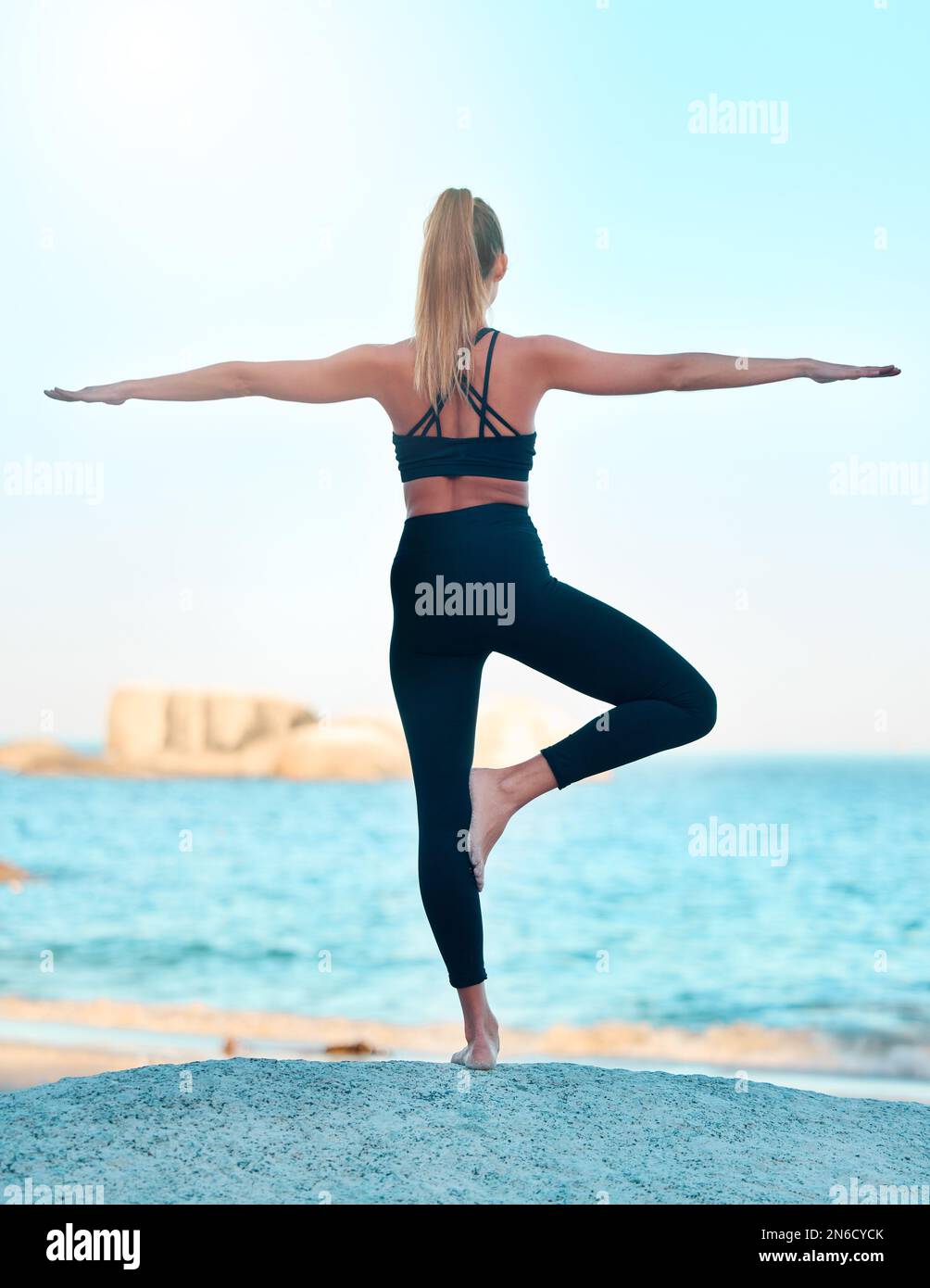 Vision belle femme pratiquant l'exercice de yoga sur la plage. Jeune athlète féminine s'étirant en s'étirant à l'extérieur. Trouver la paix intérieure et Banque D'Images