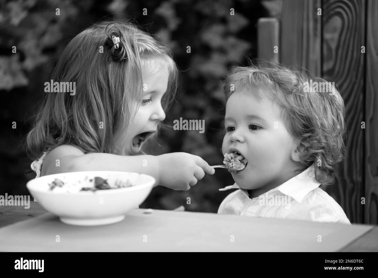 Sœur allaitant bébé garçon.La fille nourrit le frère avec une cuillère.Nourriture pour enfants. Banque D'Images