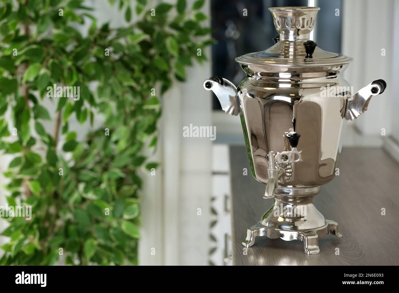 Samovar en métal sur comptoir en bois dans la cuisine, espace pour le texte. Culture du thé russe Banque D'Images