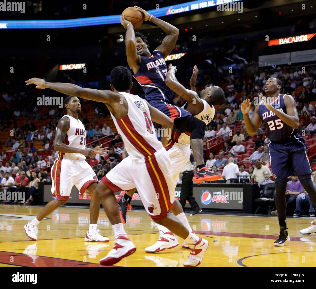 Atlanta Hawks' James Johnson, center, fouls Miami Heat's Jarvis Varnado, second from right, as Johnson looks to pass in the fourth quarter of an NBA preseason basketball game, Monday, Oct. 7, 2013, in Miami. The Heat won 92-87. (AP Photo/Alan Diaz) Banque D'Images