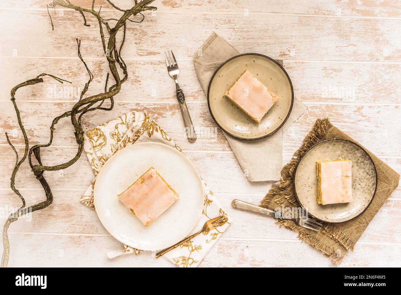 Trois assiettes avec tarte aux pommes couverte et glaçage au sucre sur fond de bois blanc. Concept de couleur harmonieuse dans les tons beige. Vue de dessus. Banque D'Images