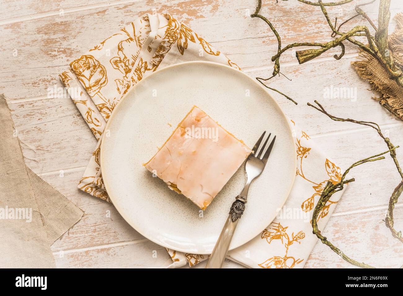 Assiette avec morceau de tarte aux pommes avec glaçage au sucre sur fond de bois blanc. Concept de couleur harmonieuse dans les tons beige. Vue de dessus. Banque D'Images