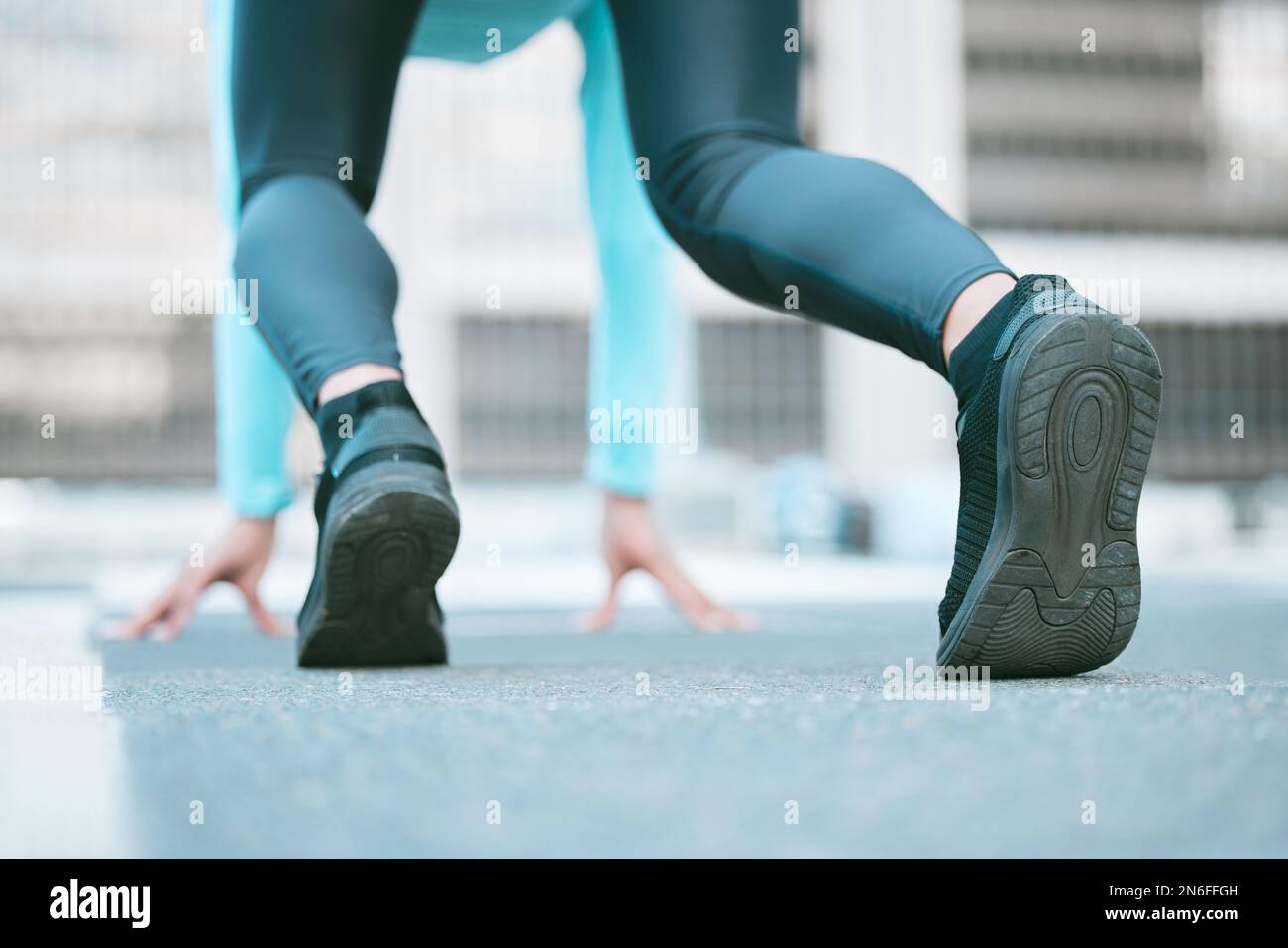 Gros plan de la semelle de chaussures d'une athlète féminine se préparant à courir en position de départ tout en s'exerçant à l'extérieur. Femme sportive portant des chaussures Banque D'Images