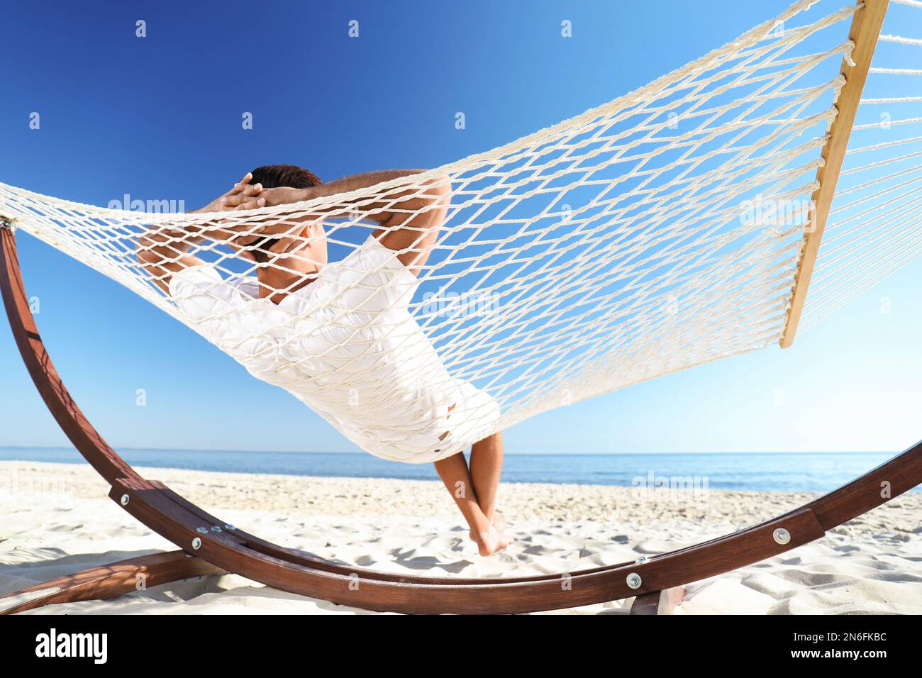 Homme relaxant dans un hamac sur la plage. Vacances d'été Photo Stock -  Alamy