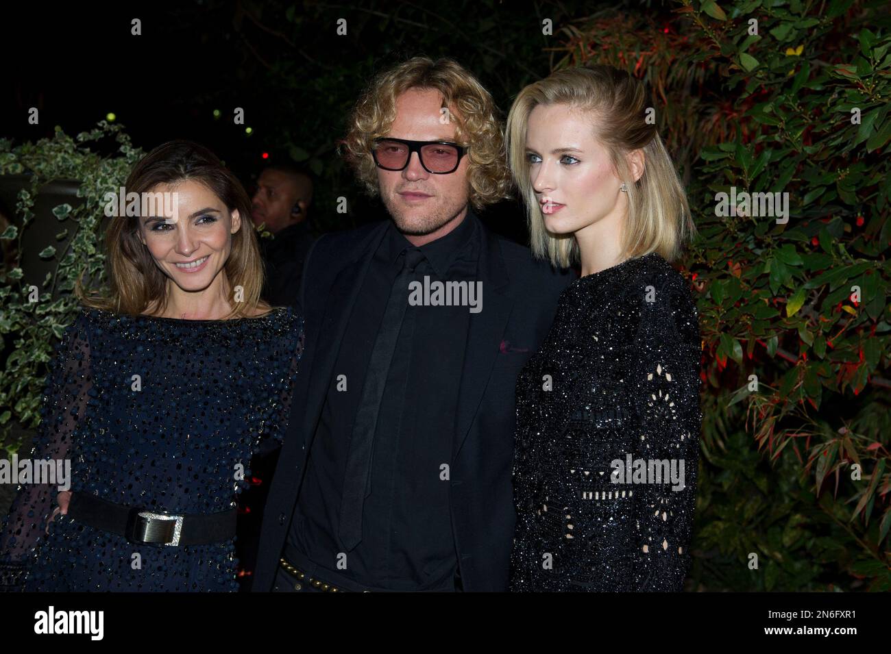 Clotilde Courau, left, designer Peter Dundas, center, and russian model Daria Strokous are posing for the photographers as they arrive to attend the Mademoiselle C Fashion Week VIP Screening after party, in Paris, Tuesday, Oct.1, 2013. (AP Photo/Zacharie Scheurer) Banque D'Images
