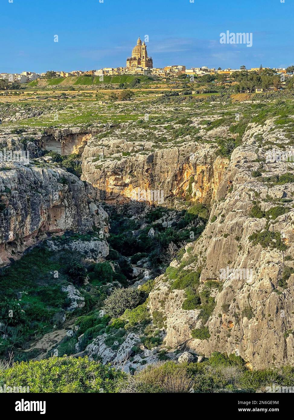 Grande difficulté d'escalade gorge Mgarr ix-Xini, en arrière-plan Basilique de Saint Jean Baptiste, Basilique Saint Jean Baptiste, Xewkija, île Gozo, Malte Banque D'Images