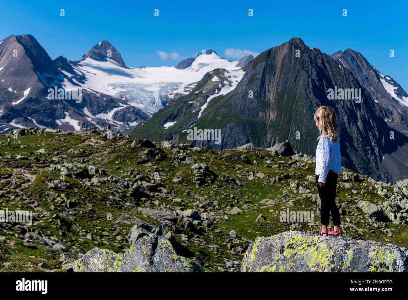 Jeune fille posant devant les Alpes suisses, col de Nufenen, Suisse Banque D'Images