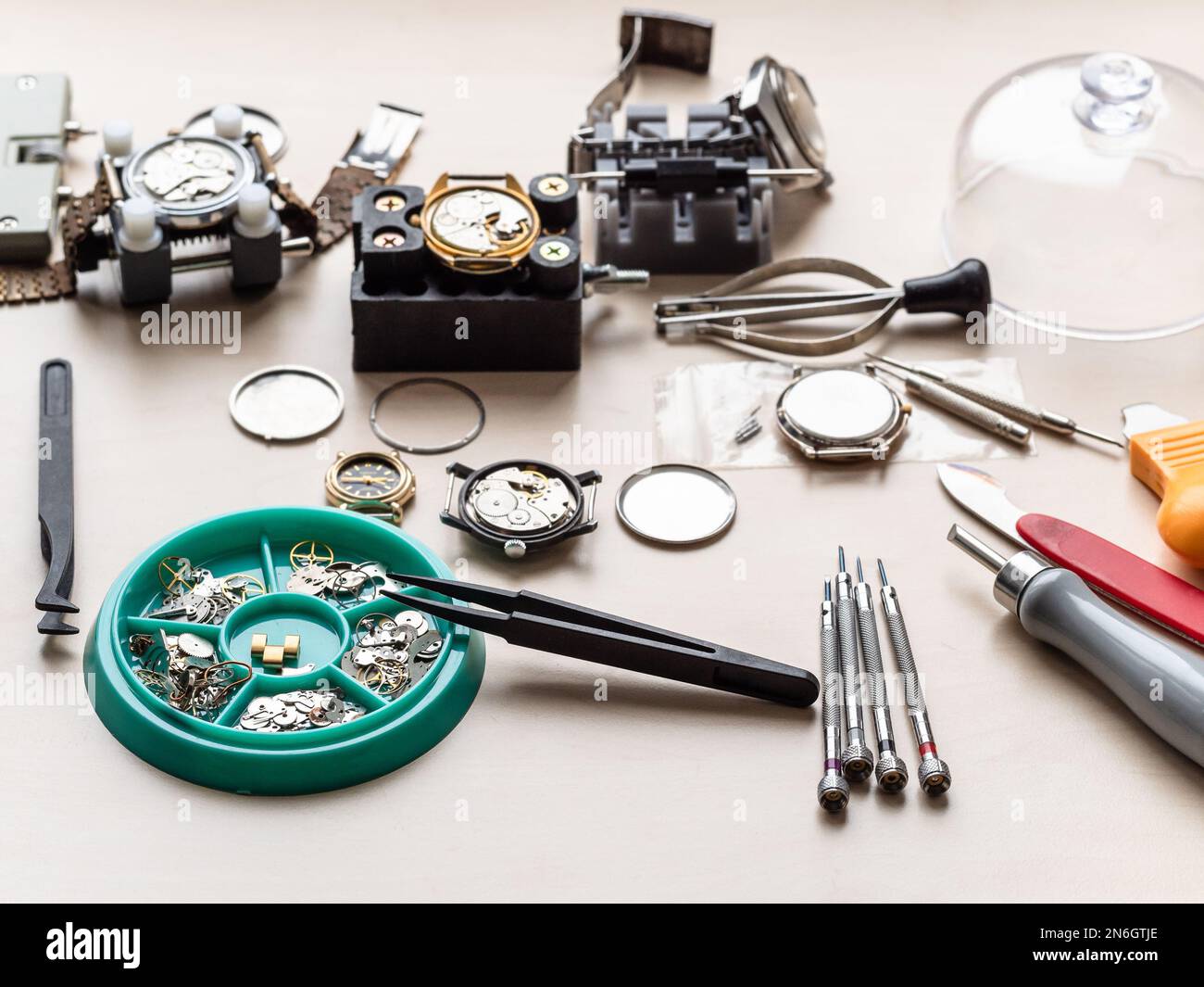 pièces de rechange, outils et vieilles montres sur table en bois dans l'atelier horloger Banque D'Images