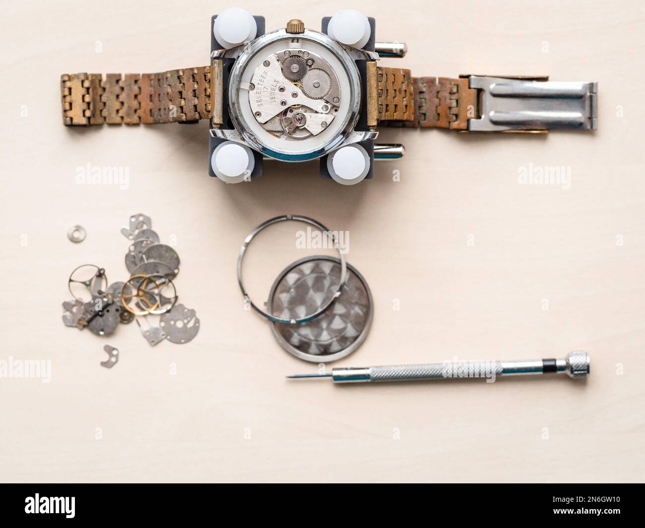 vue de dessus d'une montre-bracelet ouverte avec bracelet rouillé sur une table en bois dans un atelier horloger Banque D'Images