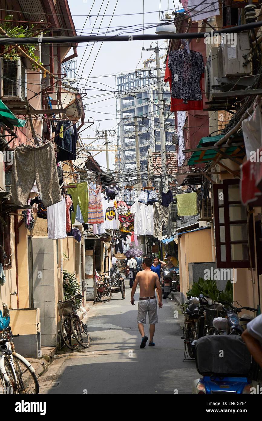 Rue dans un hutong avec linge suspendu au-dessus de la rue, Shanghai, Chine Banque D'Images