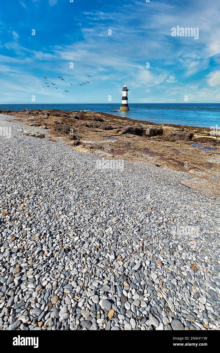 Rocky Coast avec Shingle Beach et Trwyn du Lighthouse, Penmon Lighthouse, Black point, Isle of Anglesey, pays de Galles, Royaume-Uni Banque D'Images