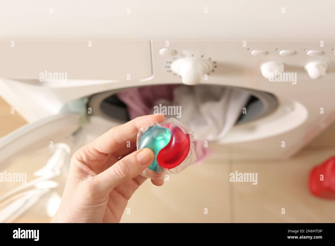 Femme tenant une capsule de détergent à lessive près du lave-linge à  l'intérieur, vue de dessus Photo Stock - Alamy