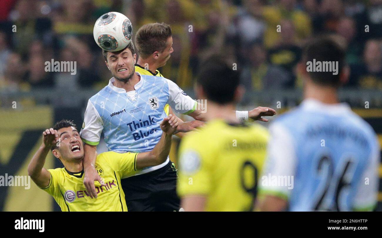 Munich's Moritz Stoppelkamp, top, and Dortmund's Nuri Sahin of Turkey challenge for the ball during the German soccer cup second round match between TSV 1860 Munich and Borussia Dortmund, in Munich, southern Germany, Tuesday, Sept. 24, 2013. (AP Photo/Matthias Schrader) Banque D'Images