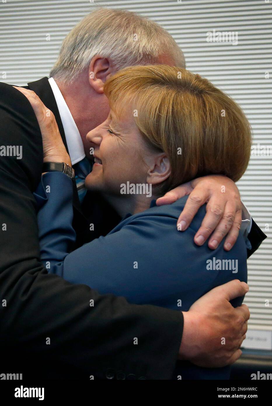German Chancellor and chairwoman of the Christian Democratic Party, CDU, Angela Merkel, right, and the chairman of the Christian Social Union, CSU, and Governor of Bavaria Horst Seehofer, left, hug each others prior to a CDU/CSU faction meeting at the German federal parliament in Berlin, Germany, Tuesday, Sept. 24, 2013, after Sunday's general election. (AP Photo/Michael Sohn) Banque D'Images