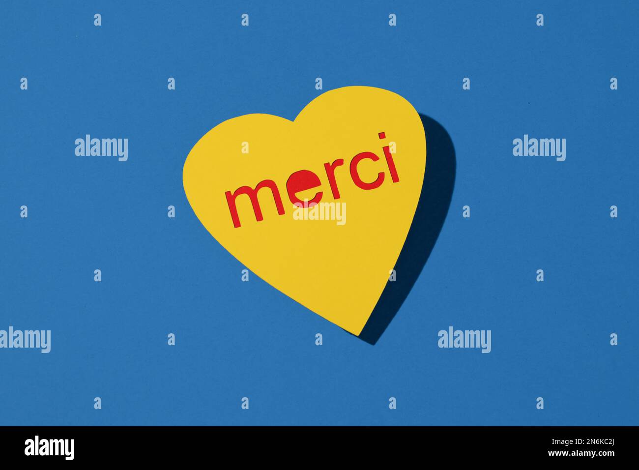 gros plan d'un signe en forme de coeur jaune qui vous lit en français, sur fond bleu Banque D'Images