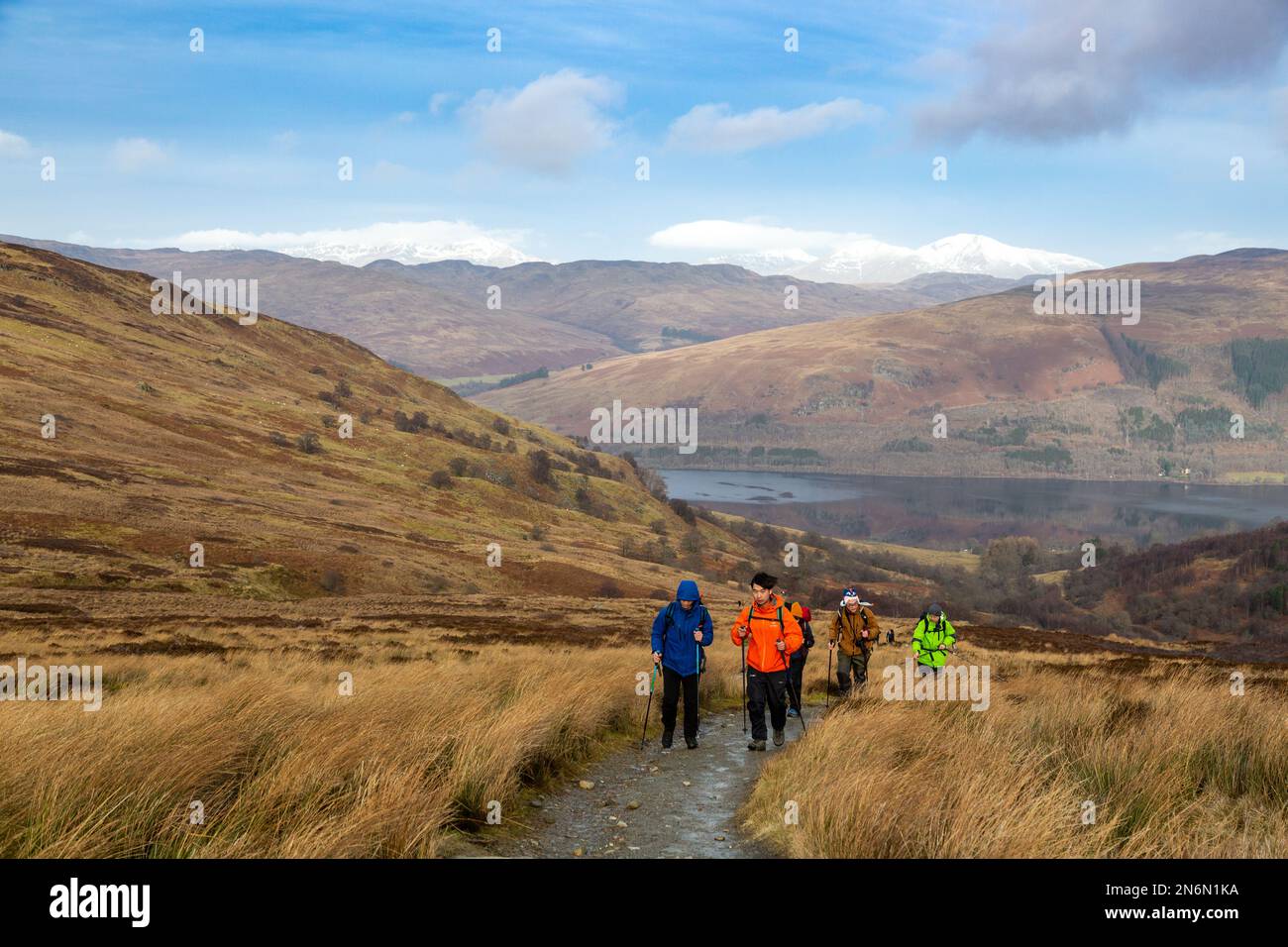 Les marcheurs sur le chemin de Ben Vorlich avec une neige bounaient Ben Lawers en arrière-plan. Banque D'Images