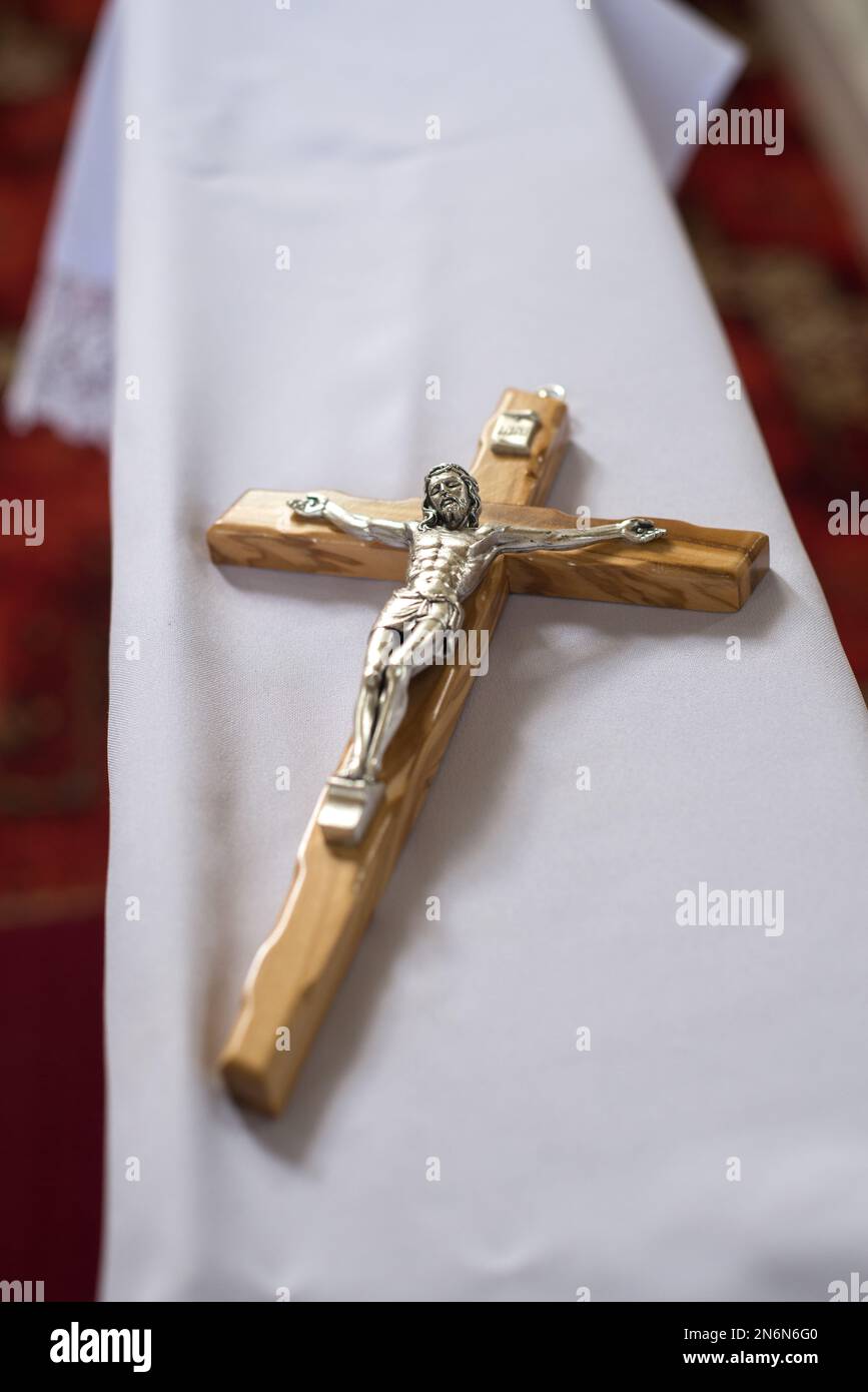 Une petite croix en bois avec Jésus-Christ placée sur un agenouiller avant le mariage Banque D'Images