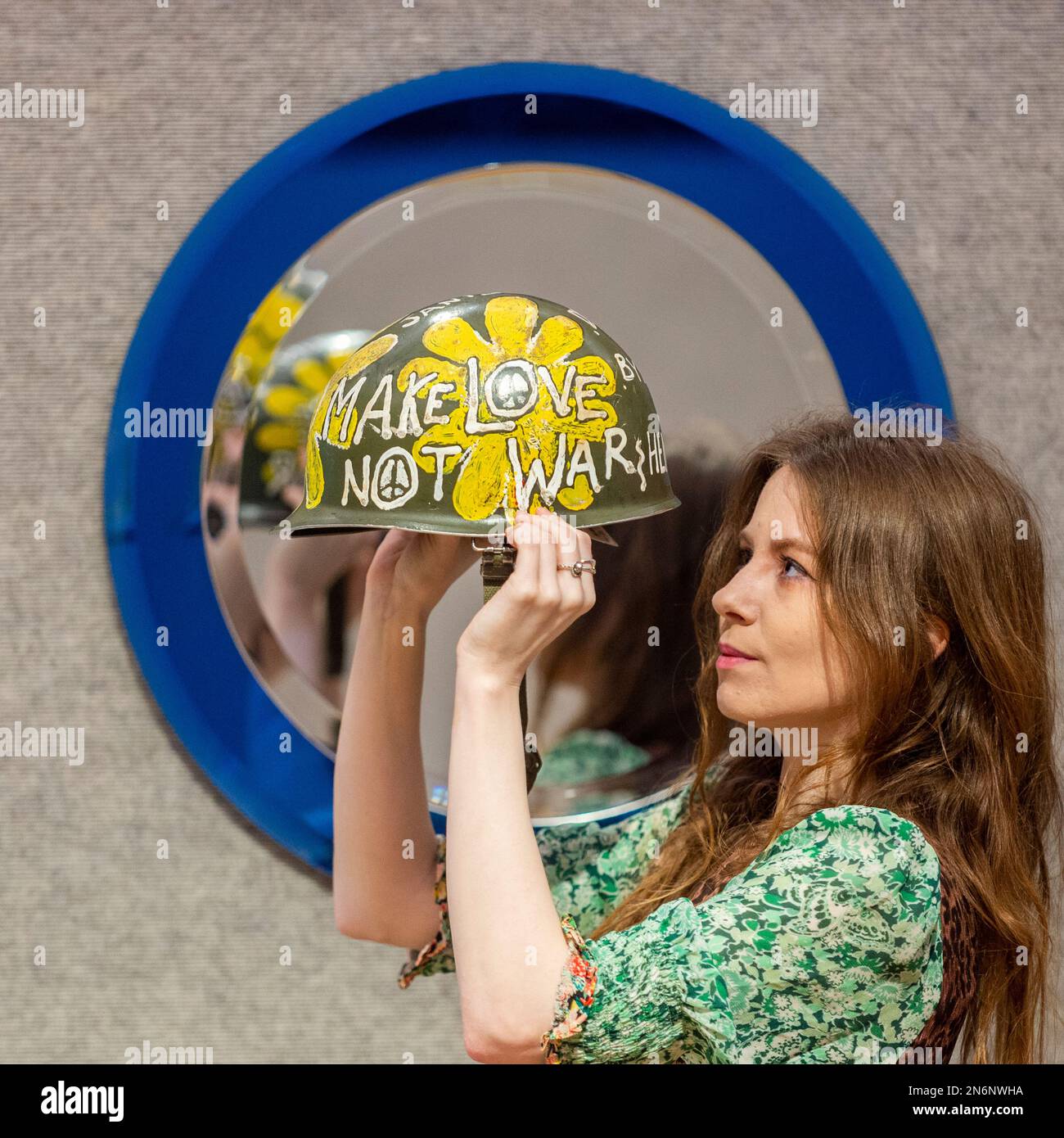 Londres, Royaume-Uni. 10 février 2023. Un membre du personnel présente Flower Power aux États-Unis Casque Vietnam, vers 1967 (est. £200 - £300) à un photocall pour la vente «Unity dans la variété: La collection David Bonsall d'arts décoratifs et de design» à Bonhams New Bond Street. 360 lots présentant des arts décoratifs du 20th siècle seront offerts à la vente le 14 février. Credit: Stephen Chung / Alamy Live News Banque D'Images
